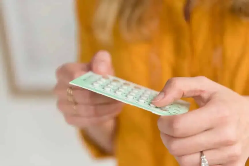 Frau mit Pillenpackung in der Hand