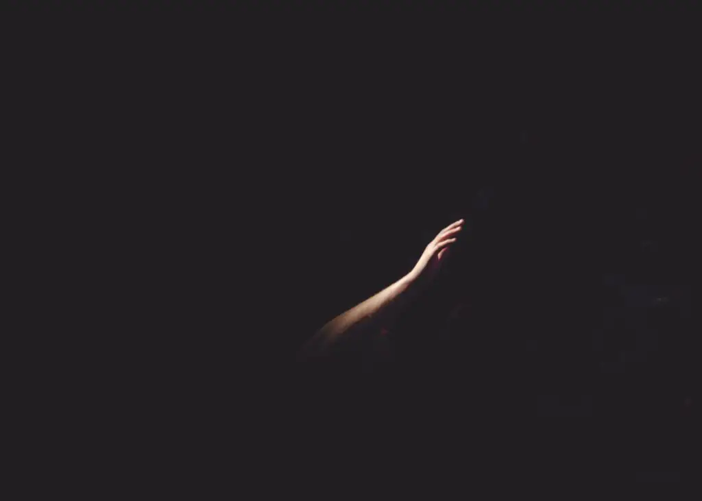 Hand in einem schwarzen Raum