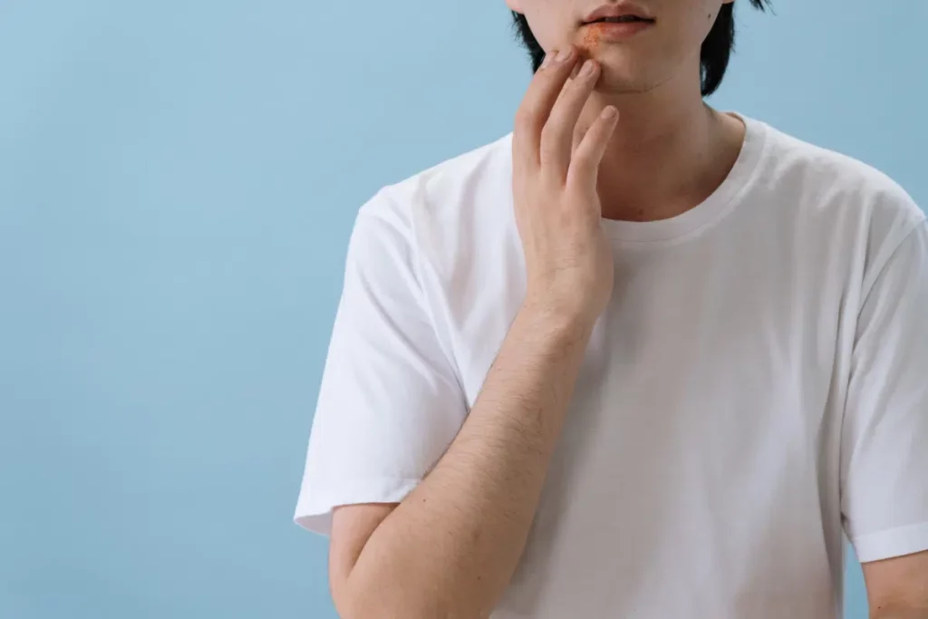 Person in weißem T-Shirt Hand am Mund